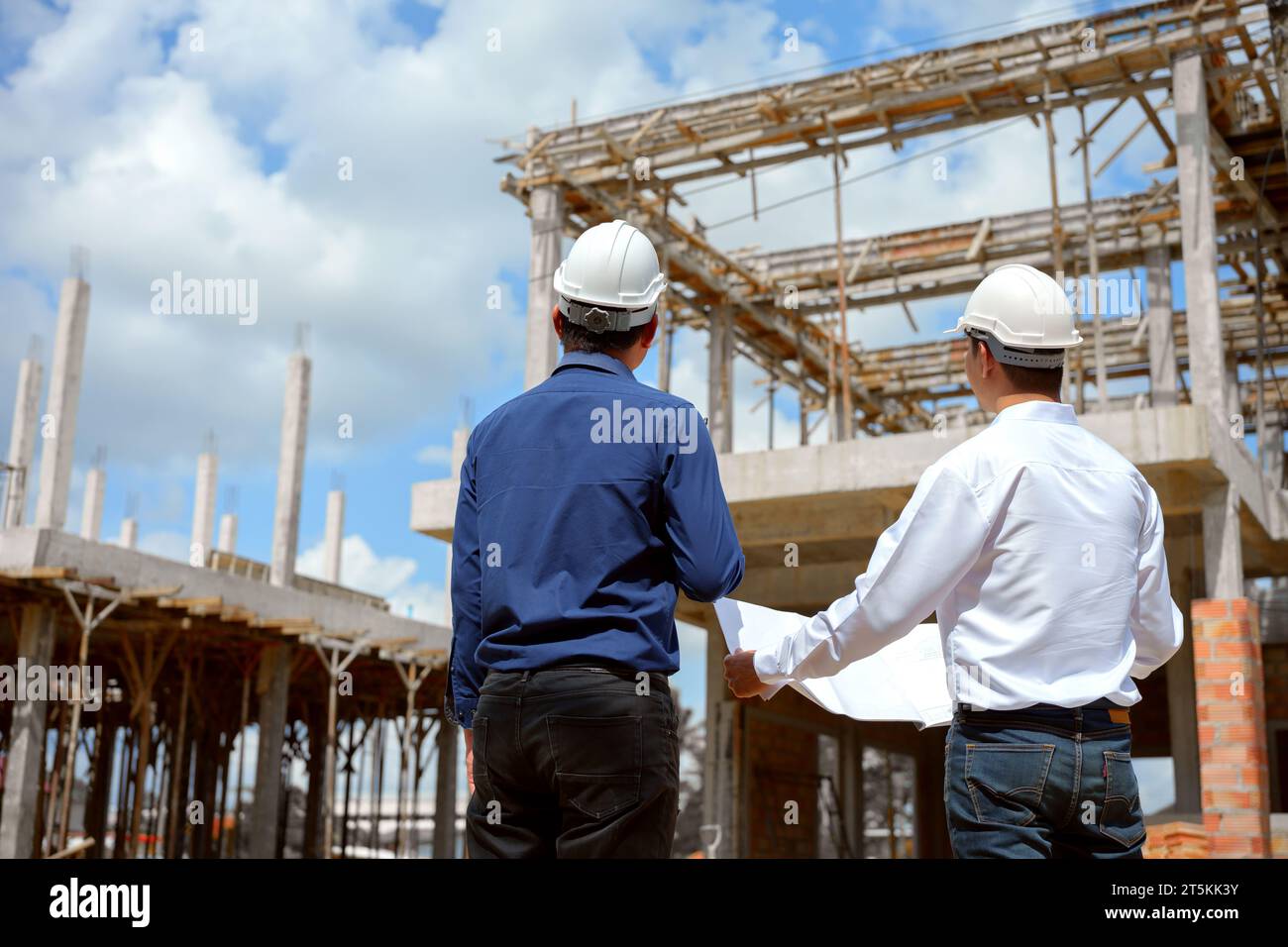 Two engineer working and checking plan on construction site. Stock Photo