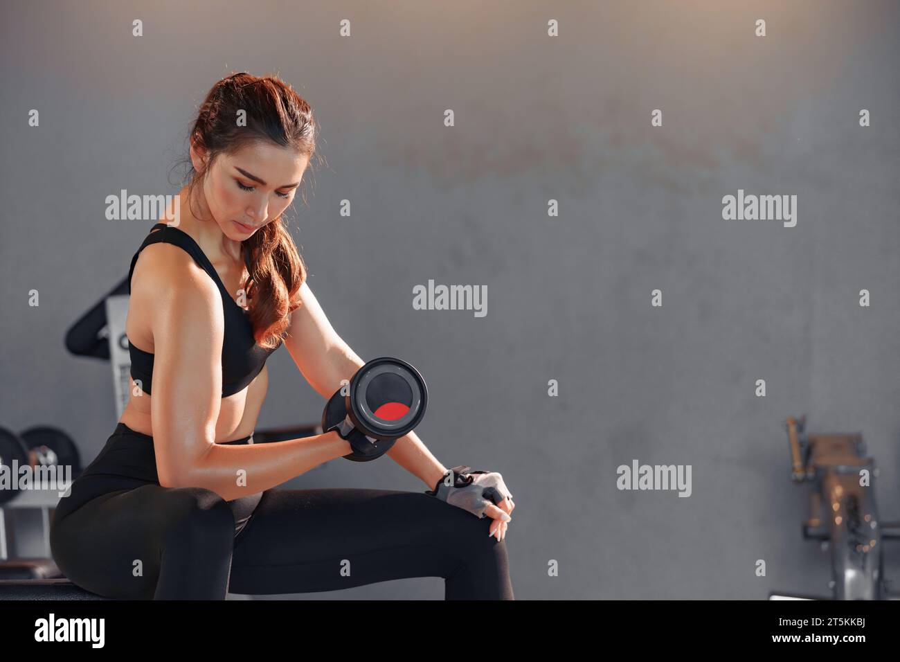 Fitness asian woman doing exercise and lifting dumbbells weights at sport gym. Stock Photo