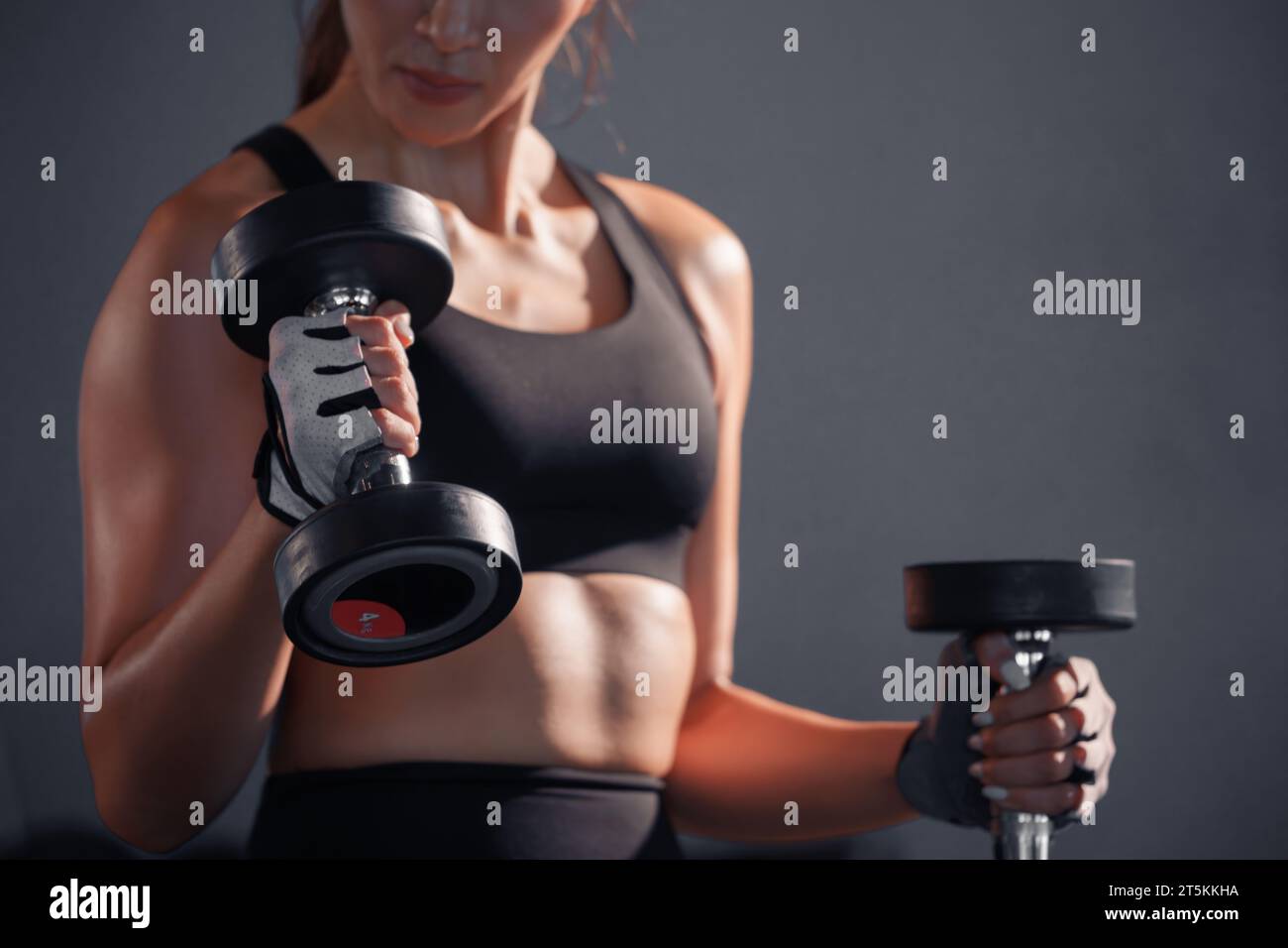 Fitness asian woman doing exercise and lifting dumbbells weights at sport gym. Stock Photo