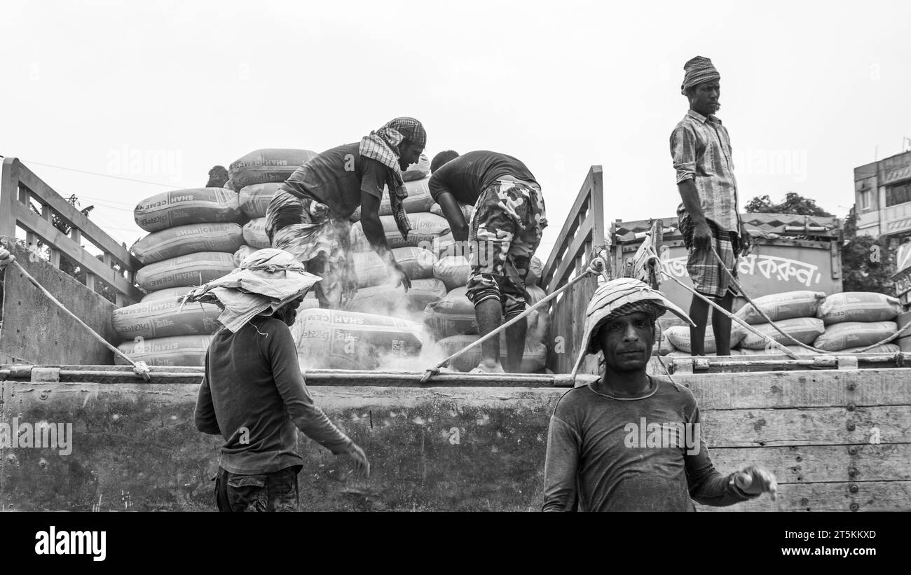 Day laborer unloading cement from the boat, This image was captured on May 29, 2022, from Amen Bazar, Bangladesh Stock Photo