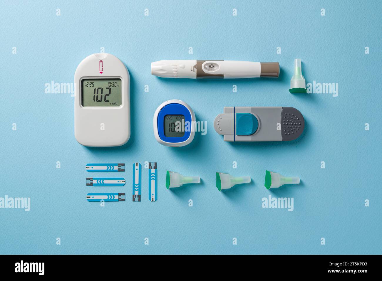 Top view of glucometer, lancet pen and strips on blue background. diabetes test kit Stock Photo