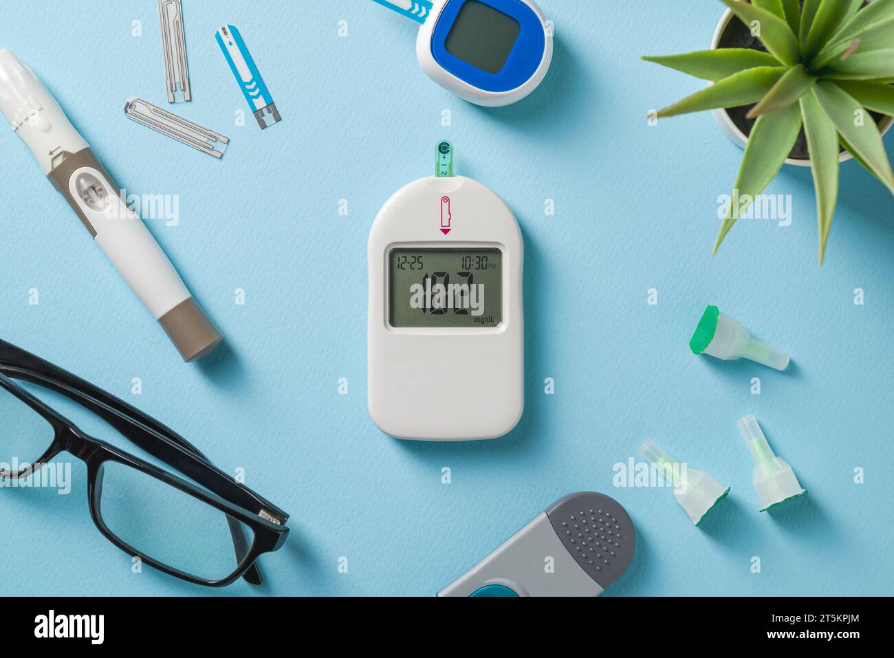 Top view of glucometer, lancet pen and strips on blue background. diabetes test kit Stock Photo