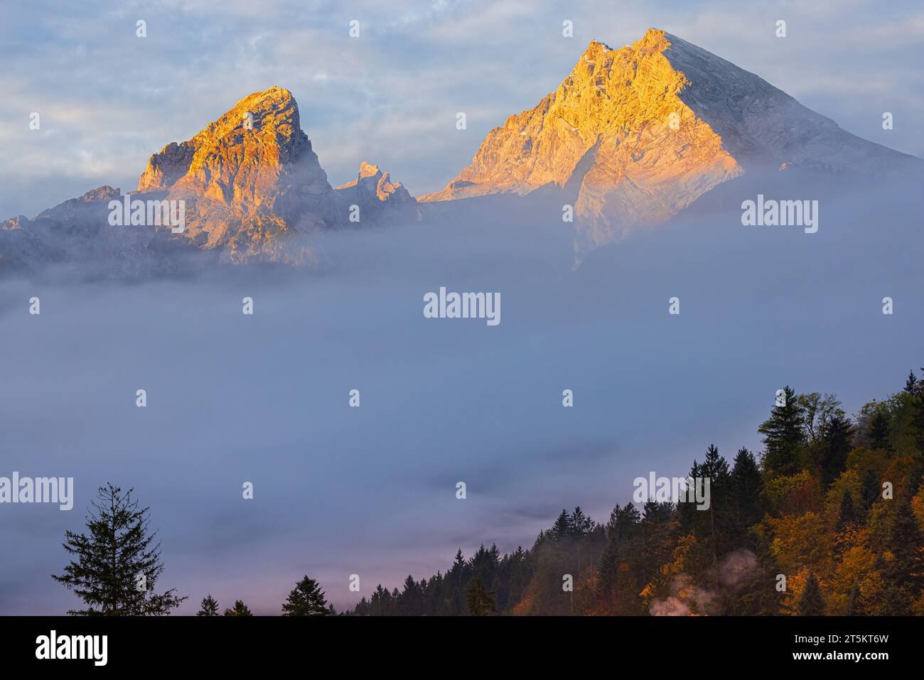 Watzmann mountain is sticking out above the clouds at an autumn sunrise near Berchtesgaden in Berchtesgadener land in Bavaria, southeastern Germany. Stock Photo