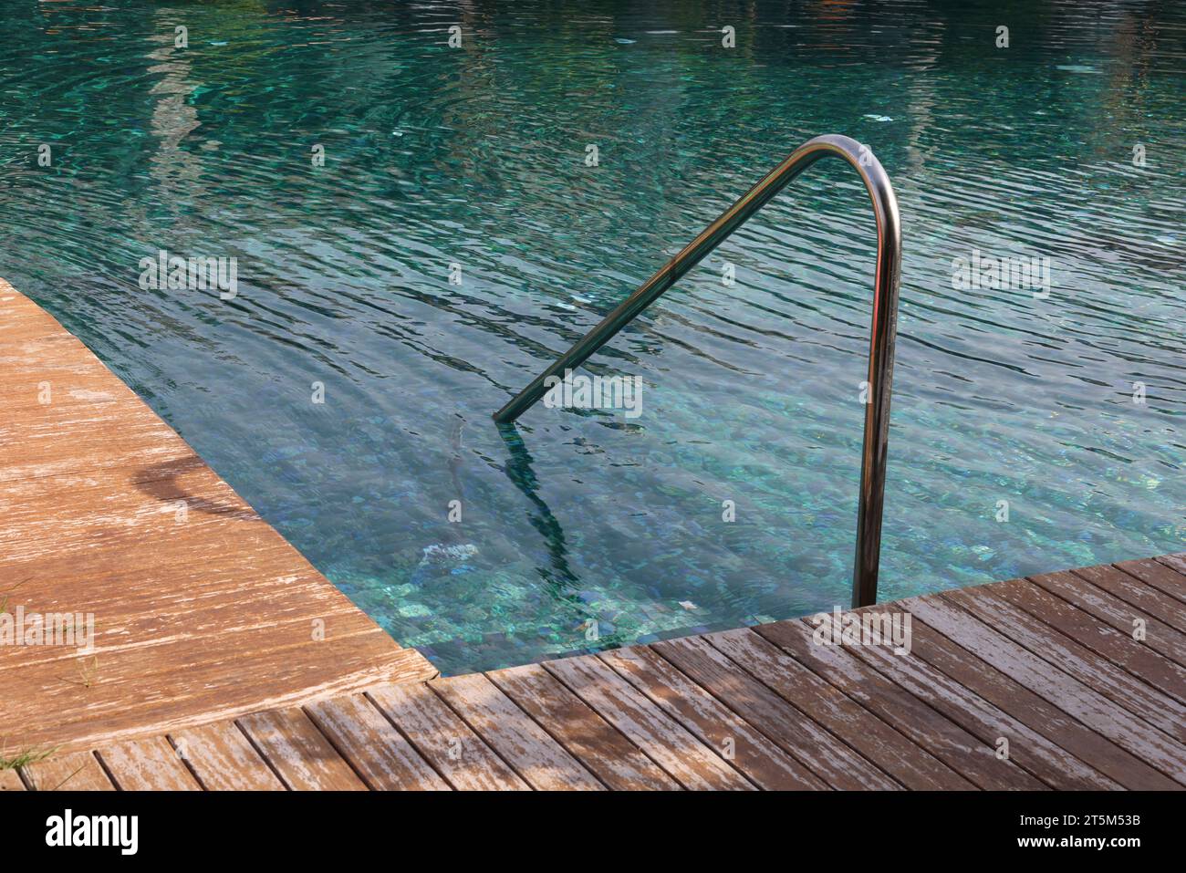 Swimming pool, metal rail and wooden deck at luxury resort Stock Photo ...
