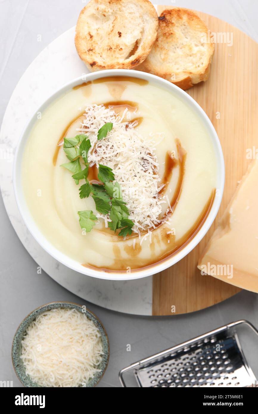 Delicious cream soup with parmesan cheese, soy sauce in bowl and