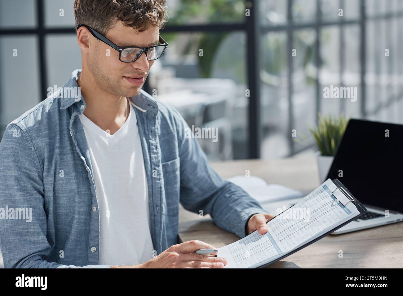 young office man at workplace making notes Stock Photo