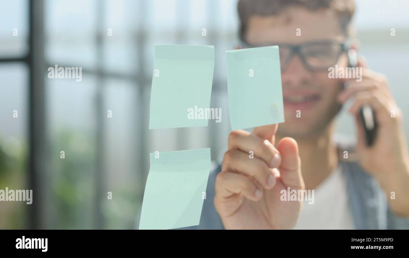 business man standing in front of stickers glass wall and write task on ...
