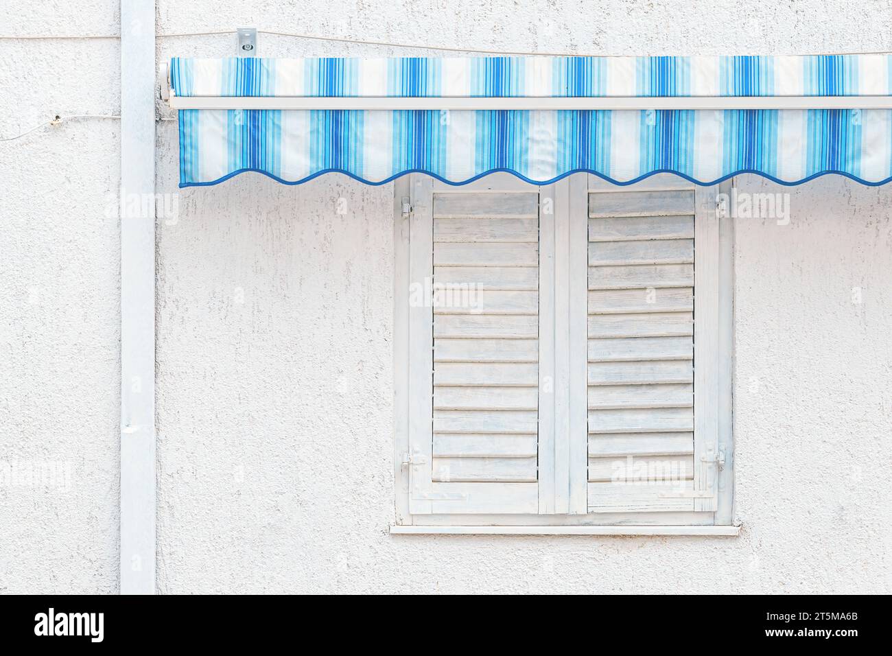 Closed white window shutters with blue awnings, detail from croatian seaside, copy space included Stock Photo
