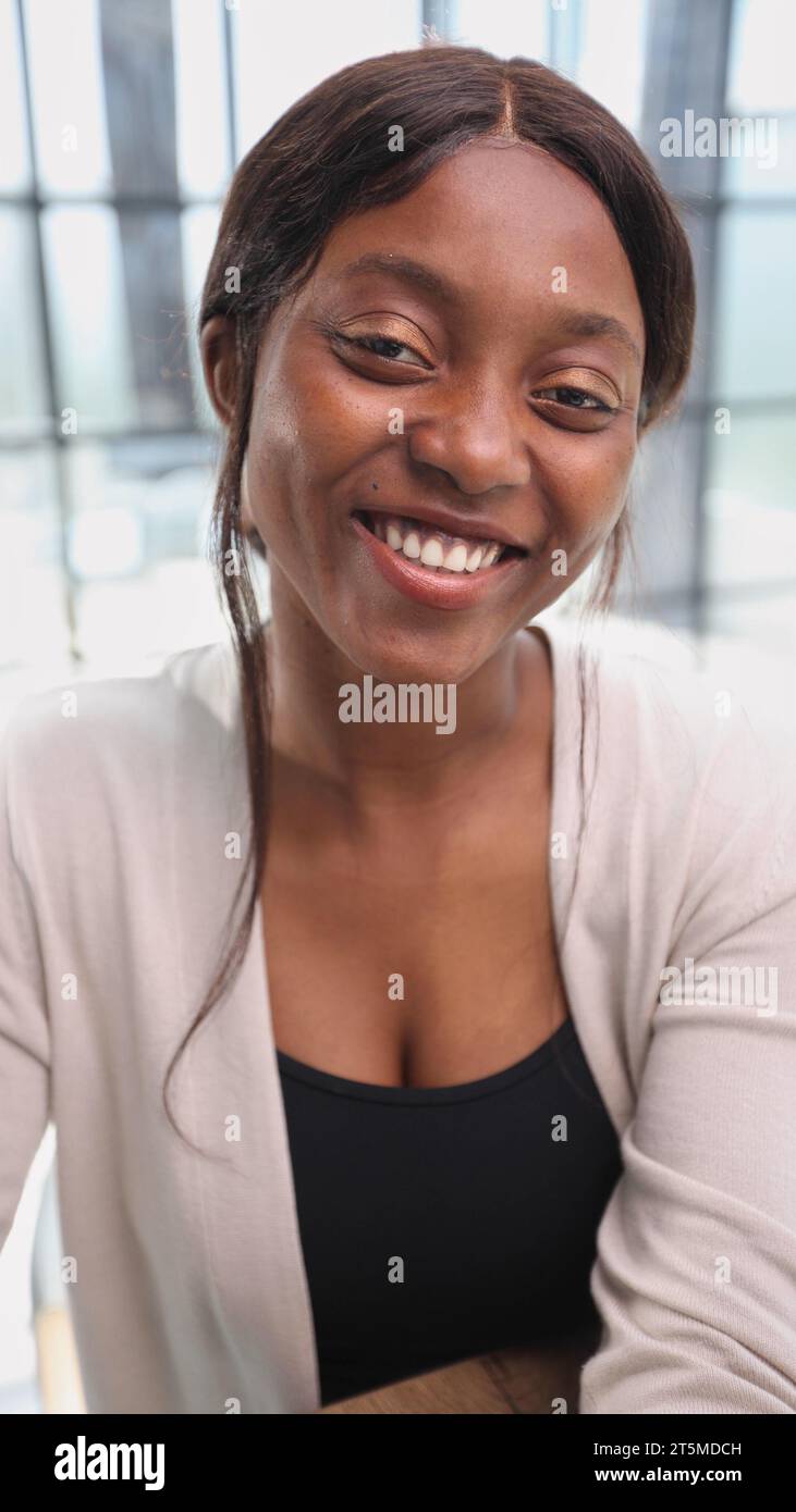 happy young african american young woman sitting in her chair smiling ...