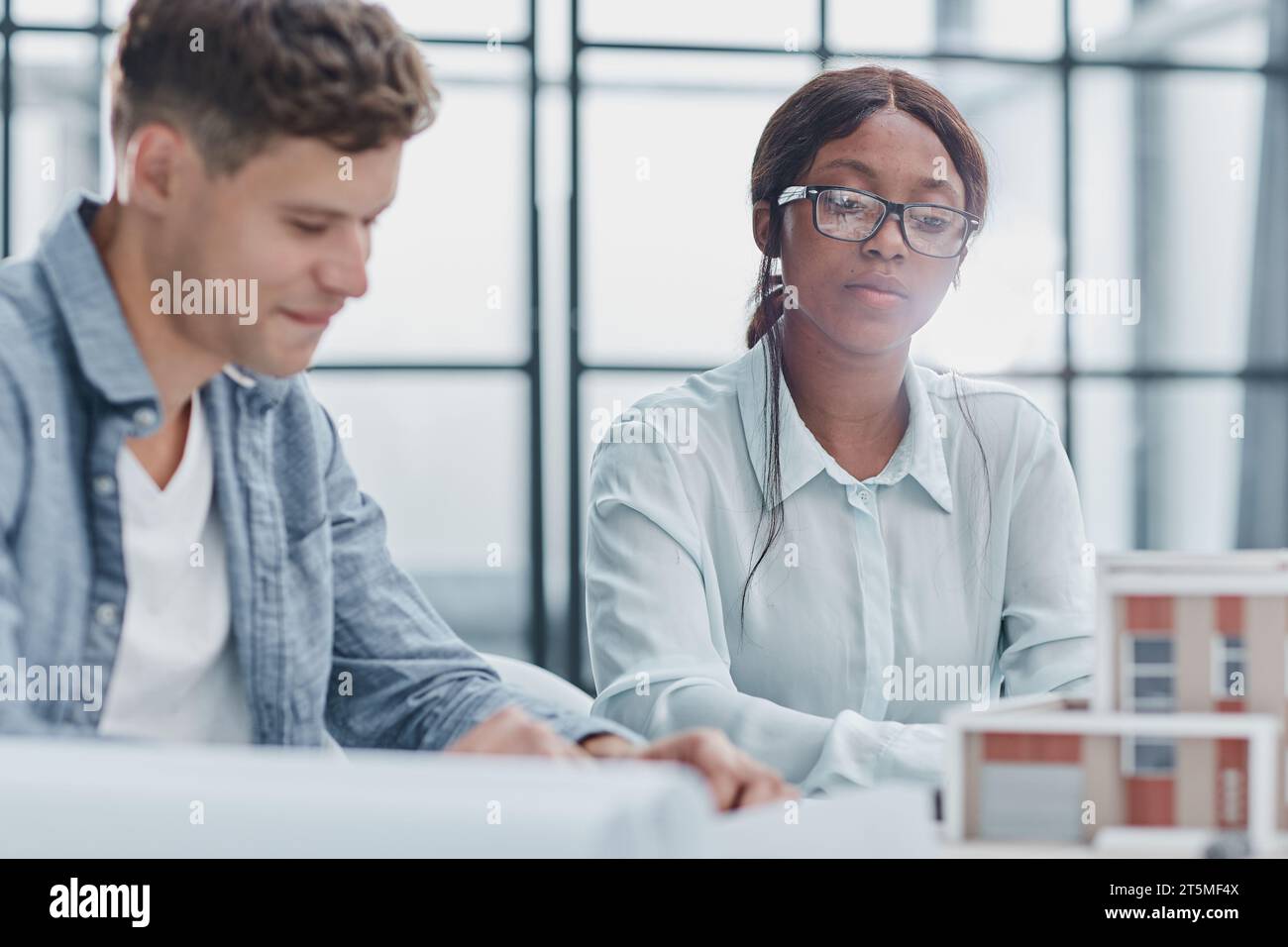 young man and woman designers architects discussing house designs Stock ...