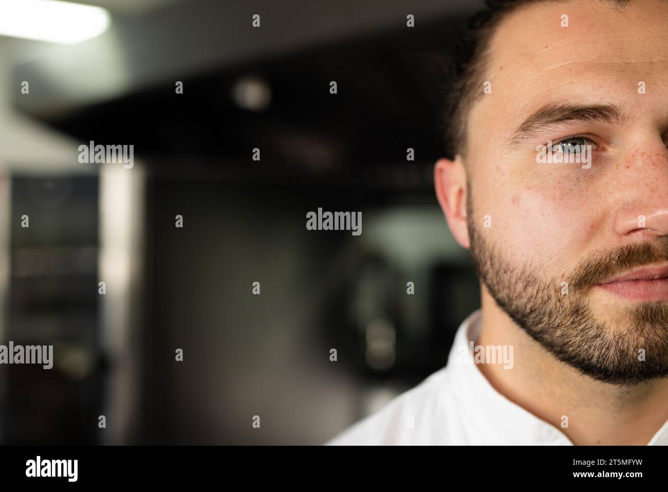 Cropped face of confident caucasian male chef looking away in restaurant kitchen, copy space Stock Photo
