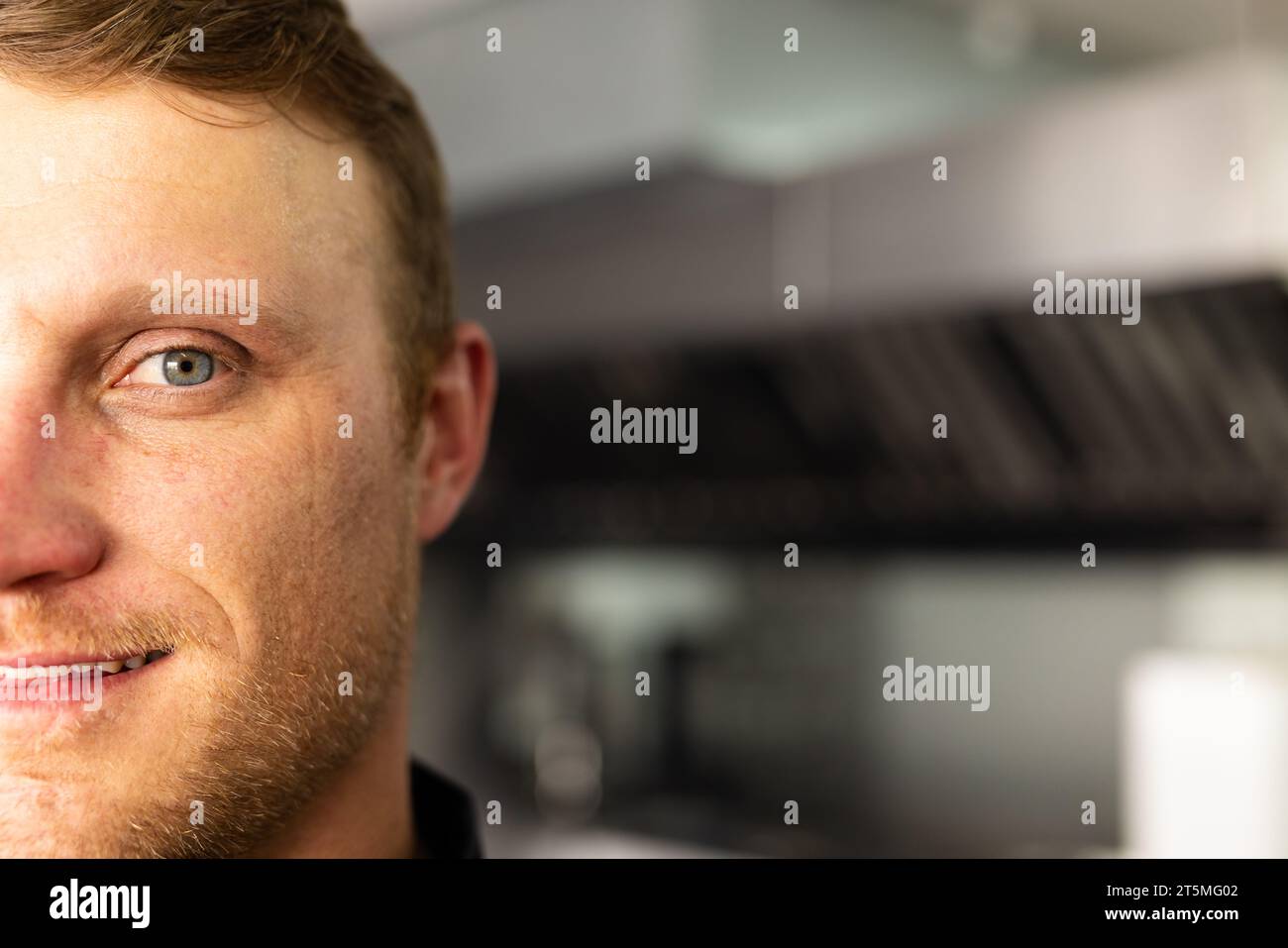 Cropped face of confident caucasian male head chef looking at camera in restaurant kitchen Stock Photo