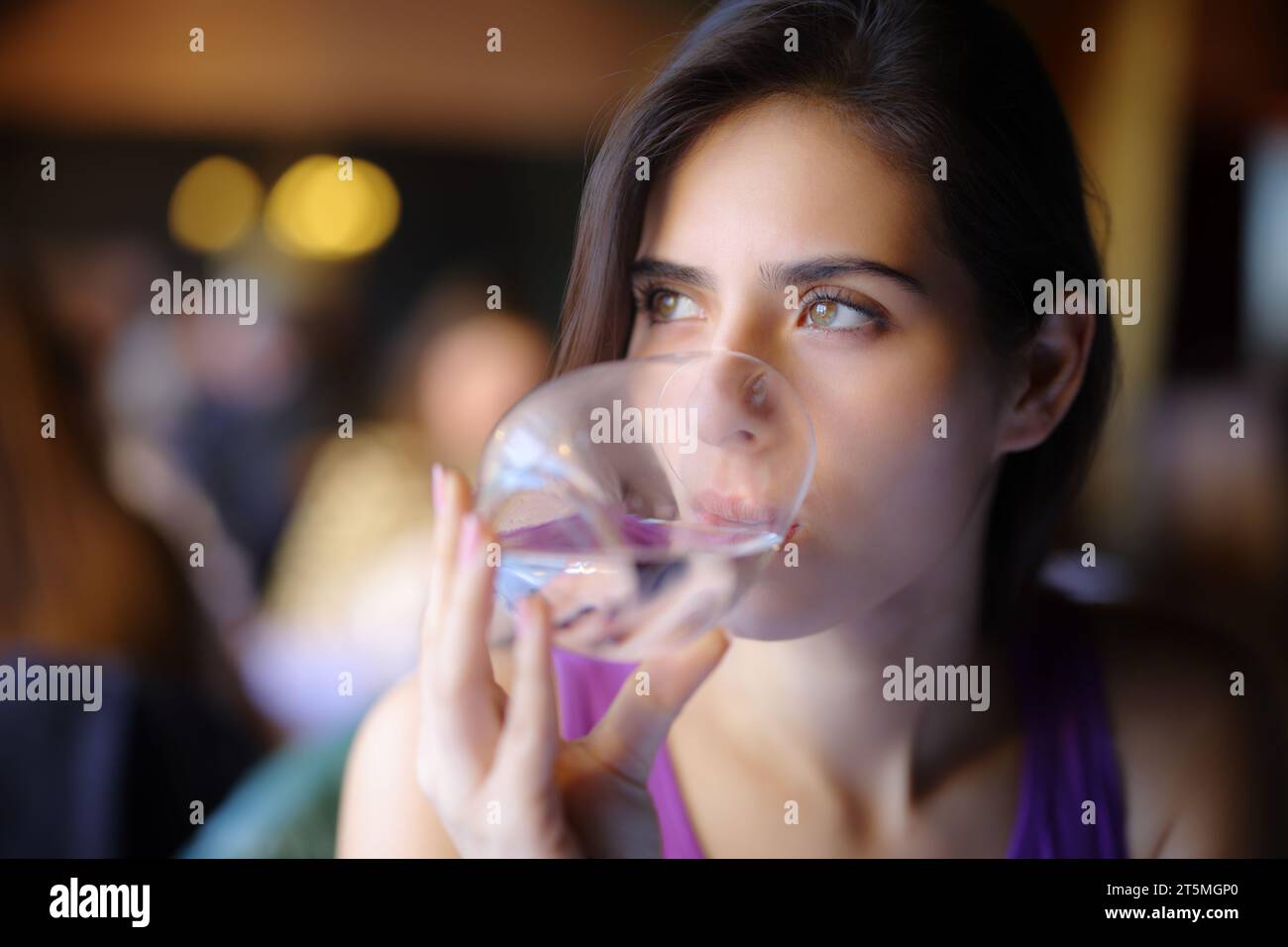 Distracted woman drinking water in a restaurant Stock Photo Alamy