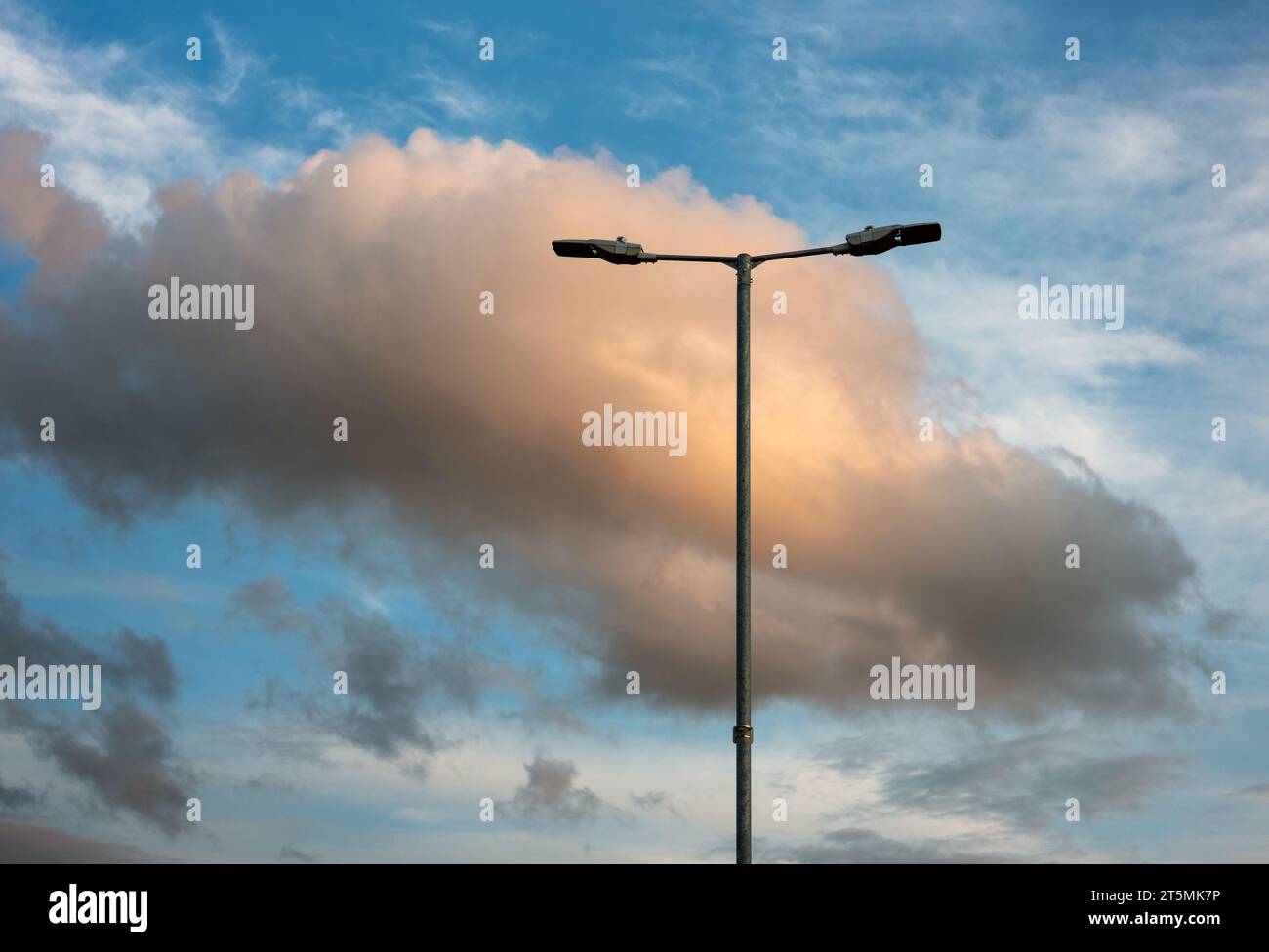 Luminous clouds behind street lighting. Stock Photo