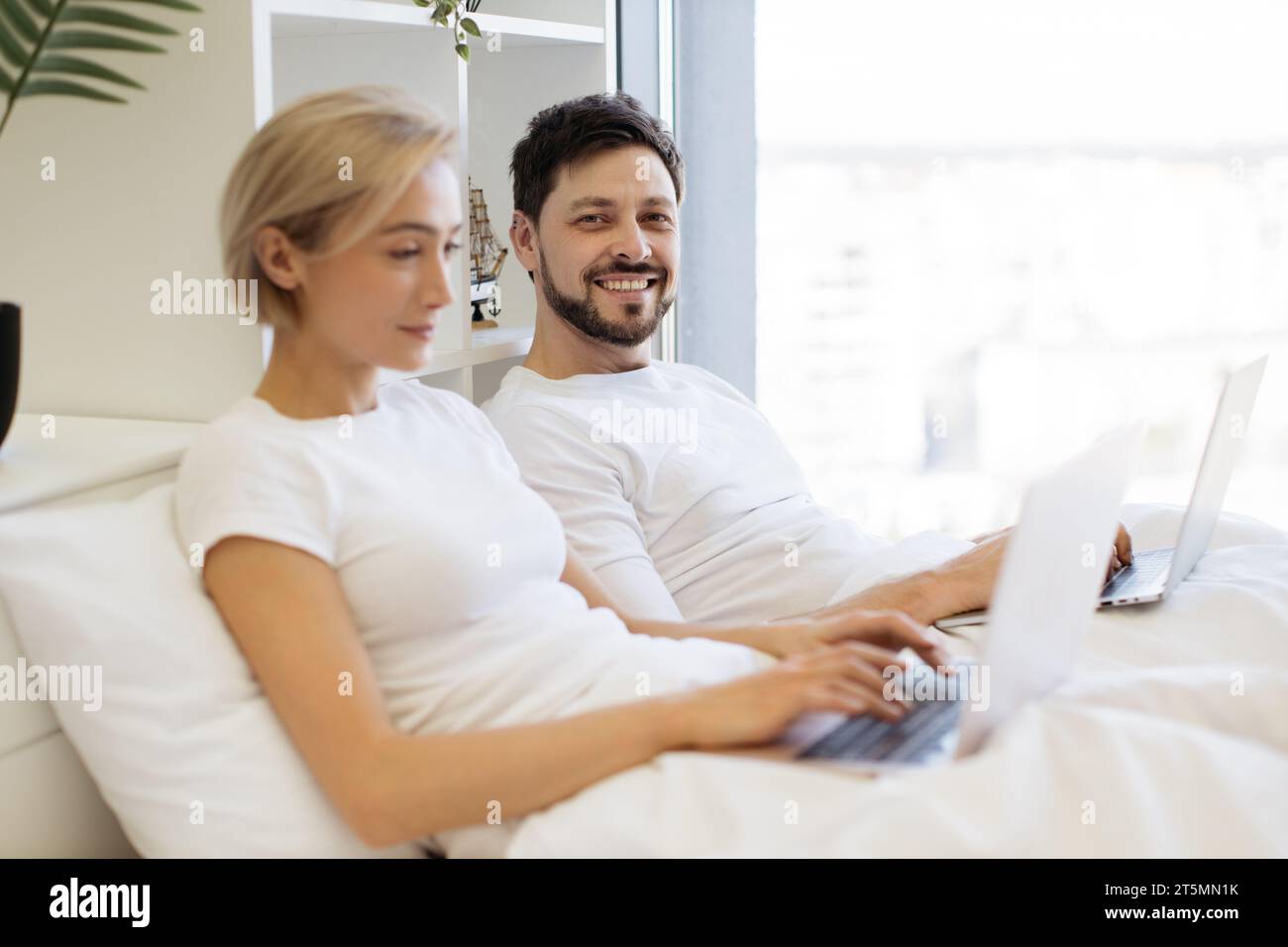 Mature people spending time at home using modern gadgets Stock Photo