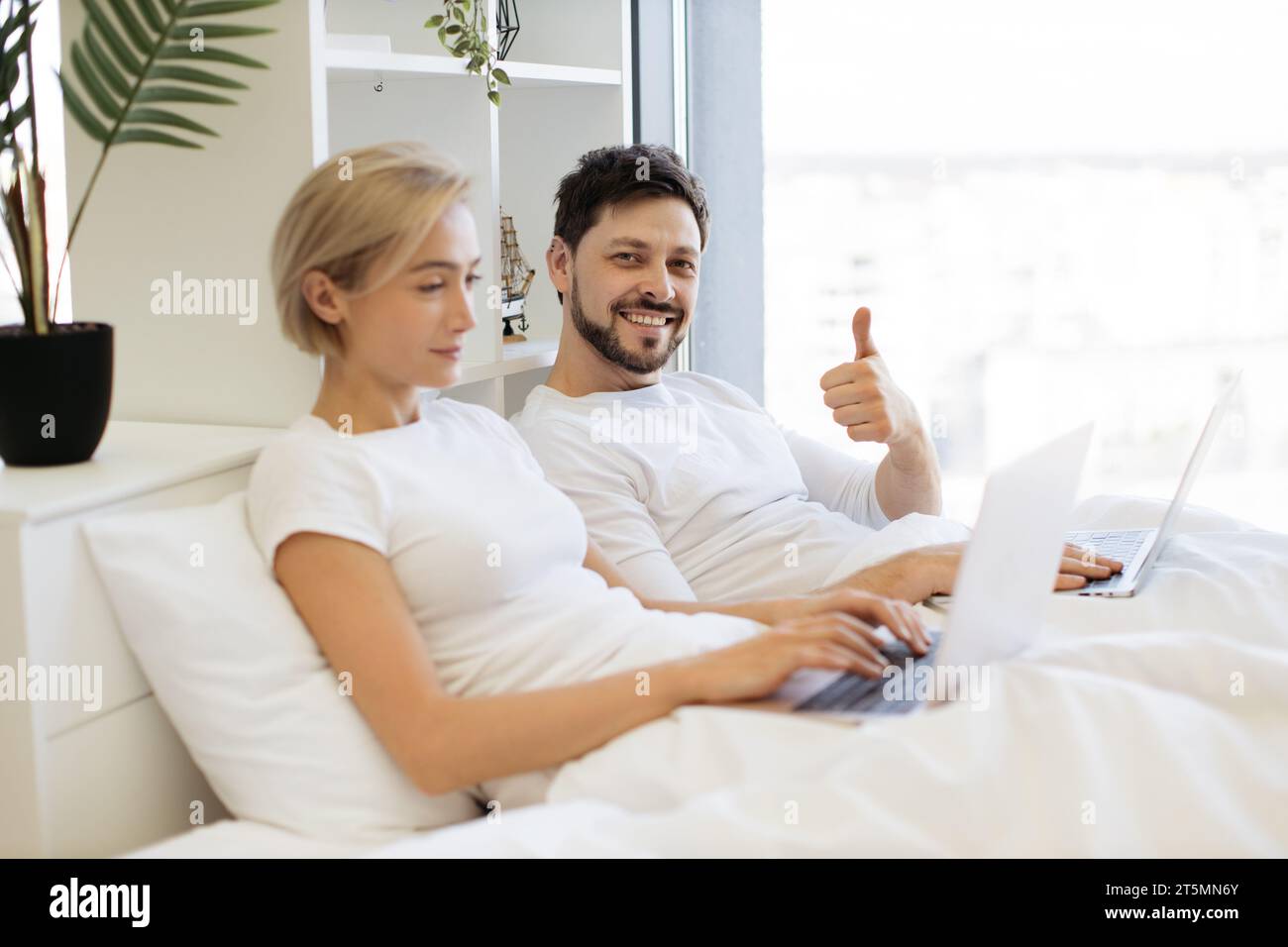 Mature people spending time at home using modern gadgets Stock Photo