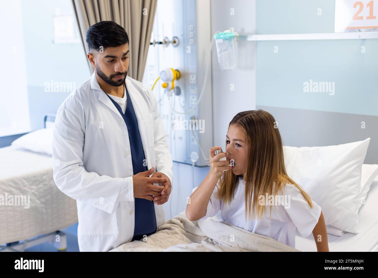 Diverse male doctor watching girl patient using asthma inhaler sitting