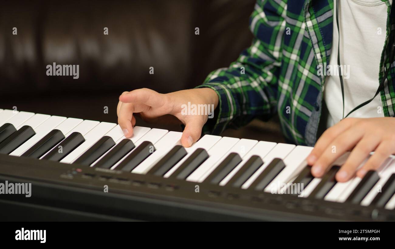 Detailed view of hands playing on the black and white keys of a digital
