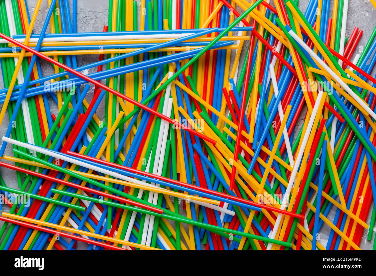 many multi-colored plastic tubes for cocktail on Colored background, top view. Stock Photo