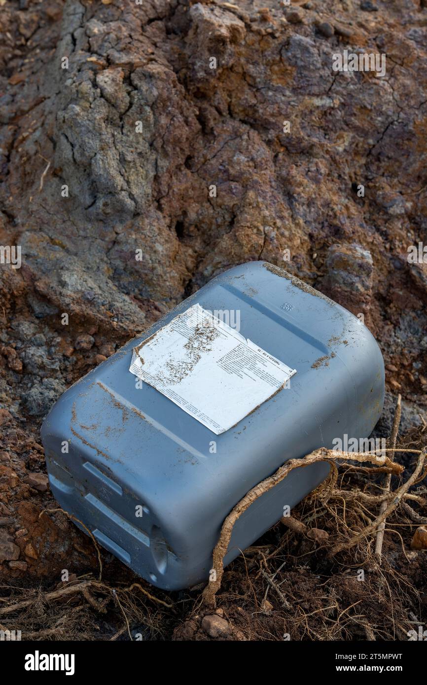 plastic chemical container washed up on a beach. hazardous waste