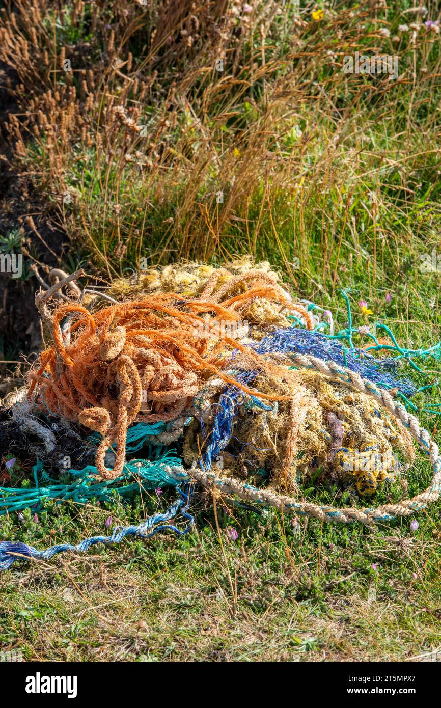 discarded fishing nets on a beach washed up after breaking free from commercial fishing boats causing a threat to the wildlife and environment an poll. Stock Photo