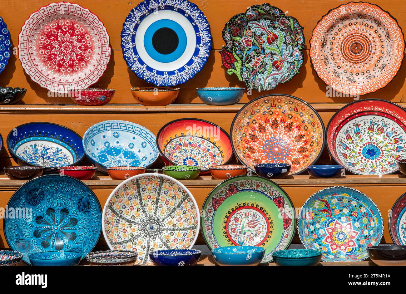 selection of brightly coloured ceramic plates and dishes on sale at a tourist shop on the greek island of crete Stock Photo