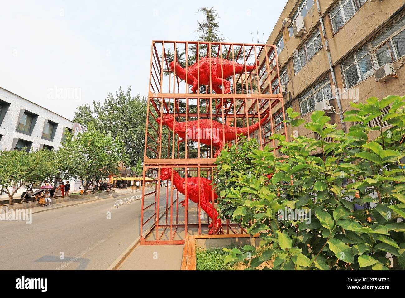 Red dinosaur sculptures in cages Stock Photo