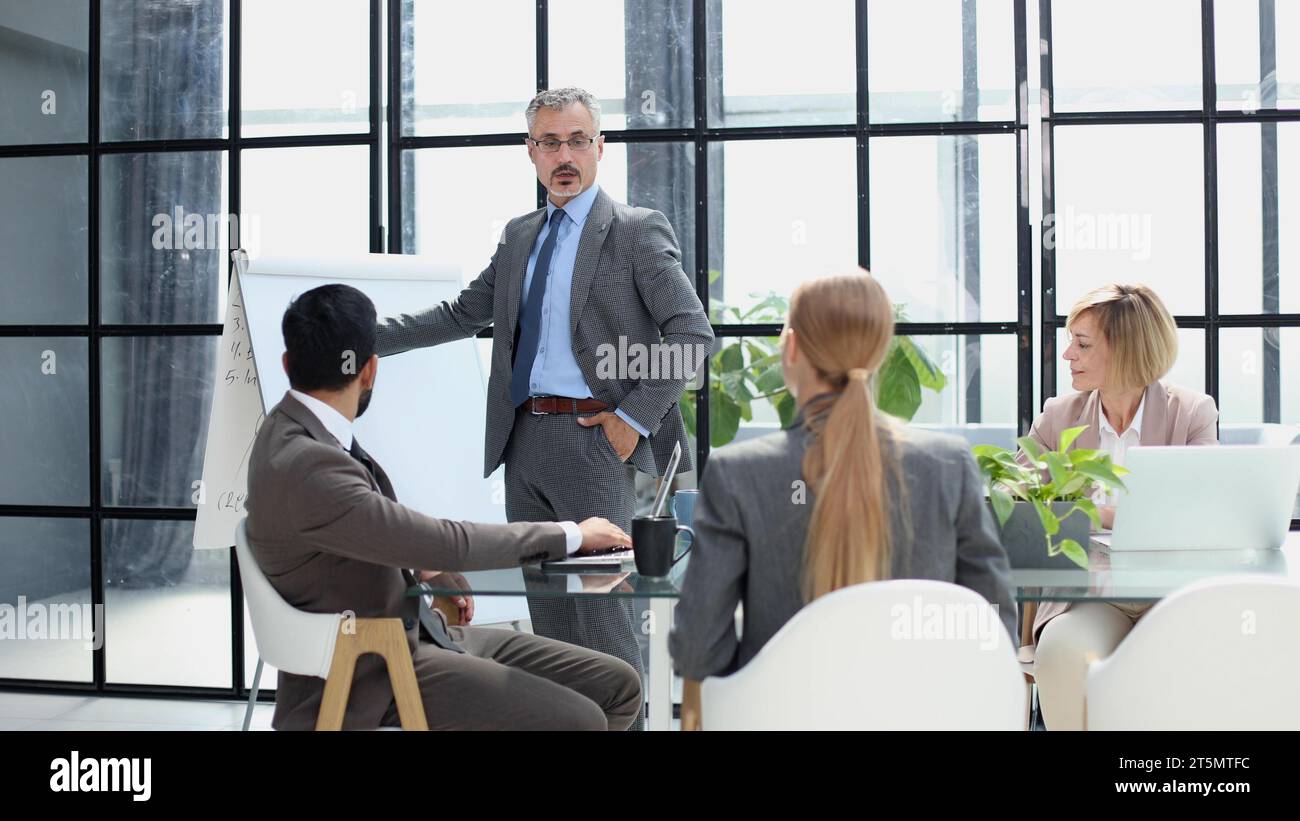 Businessman in the office writing notes on whiteboard. Stock Photo
