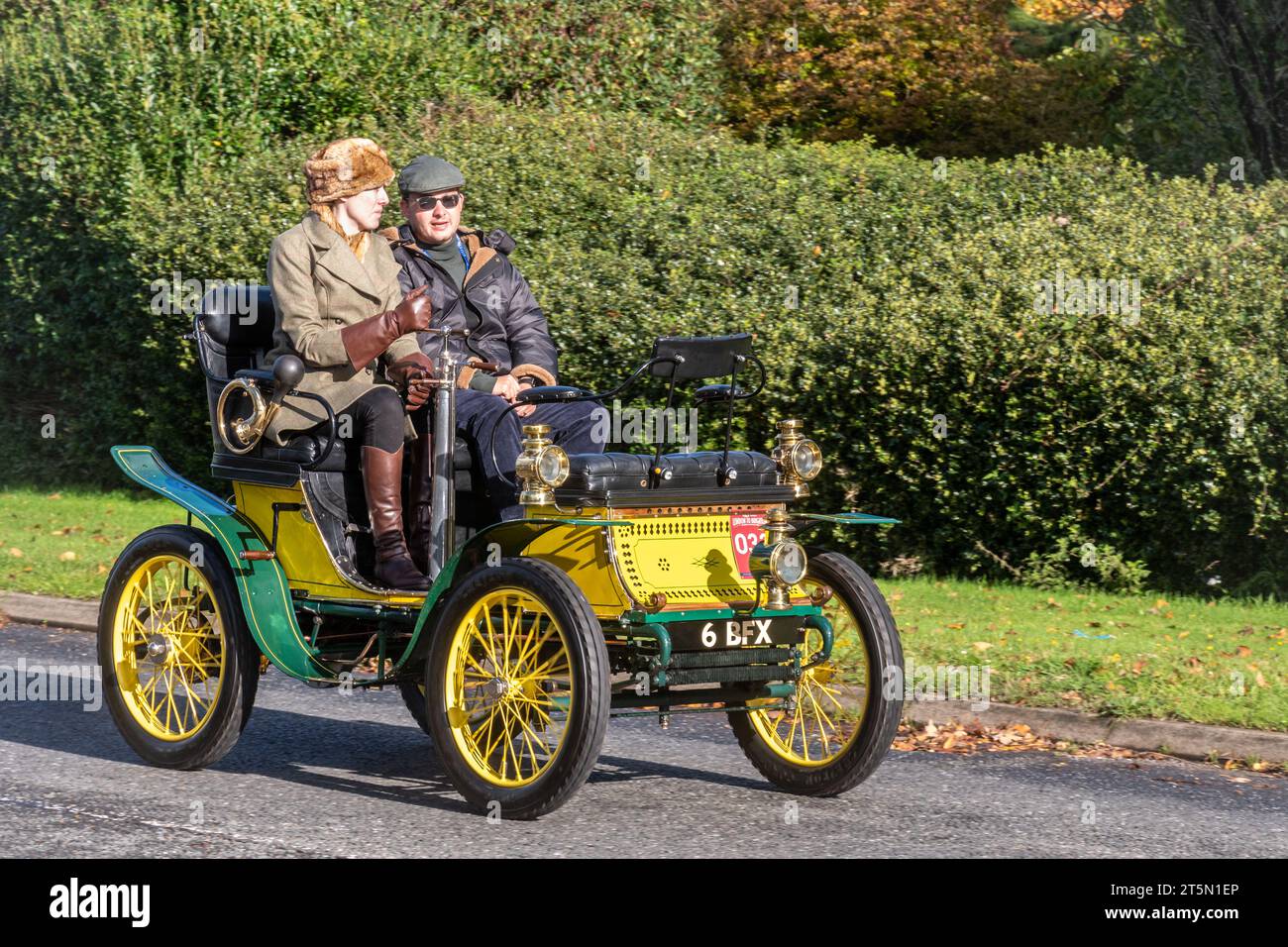 5th November 2023. Participants in the London to Brighton Veteran Car Run 2023 driving through West Sussex, England, UK. The route of the popular annual event is about 60 miles long. Pictured: a yellow and green 1900 De Dion Bouton car on the road, registration number  6 BFX. Stock Photo