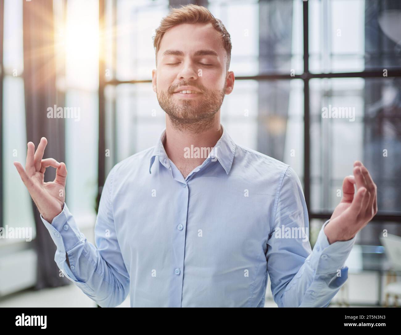 Young worker having break and resting after solving task Stock Photo