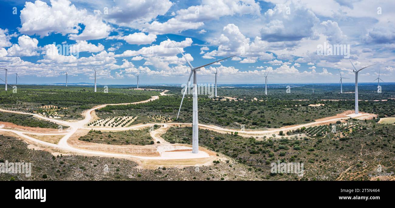 Wind turbines in rural landscape and stunning cloudy sky at the background. Environmentally friendly production of electrical energy. Stock Photo