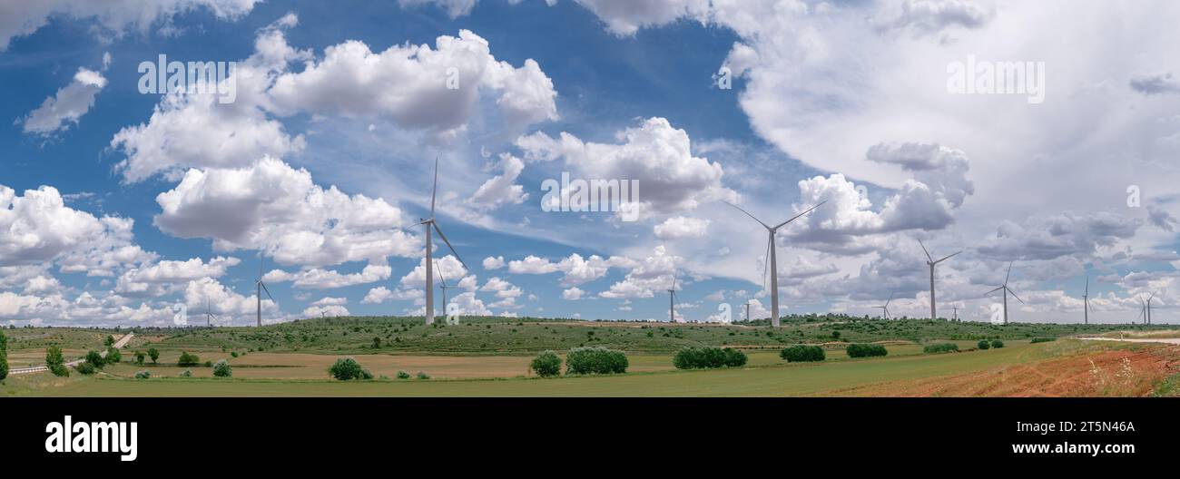Wind turbines in rural landscape and stunning cloudy sky at the background. Environmentally friendly production of electrical energy. Stock Photo