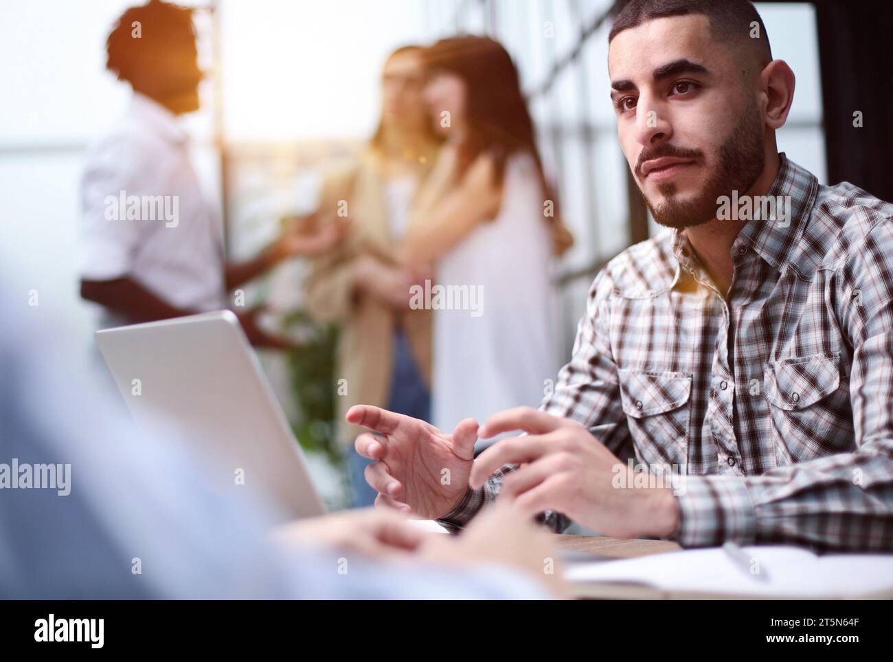 Young adult caucasian male, hiring manager, sits at a desk in a modern office Stock Photo