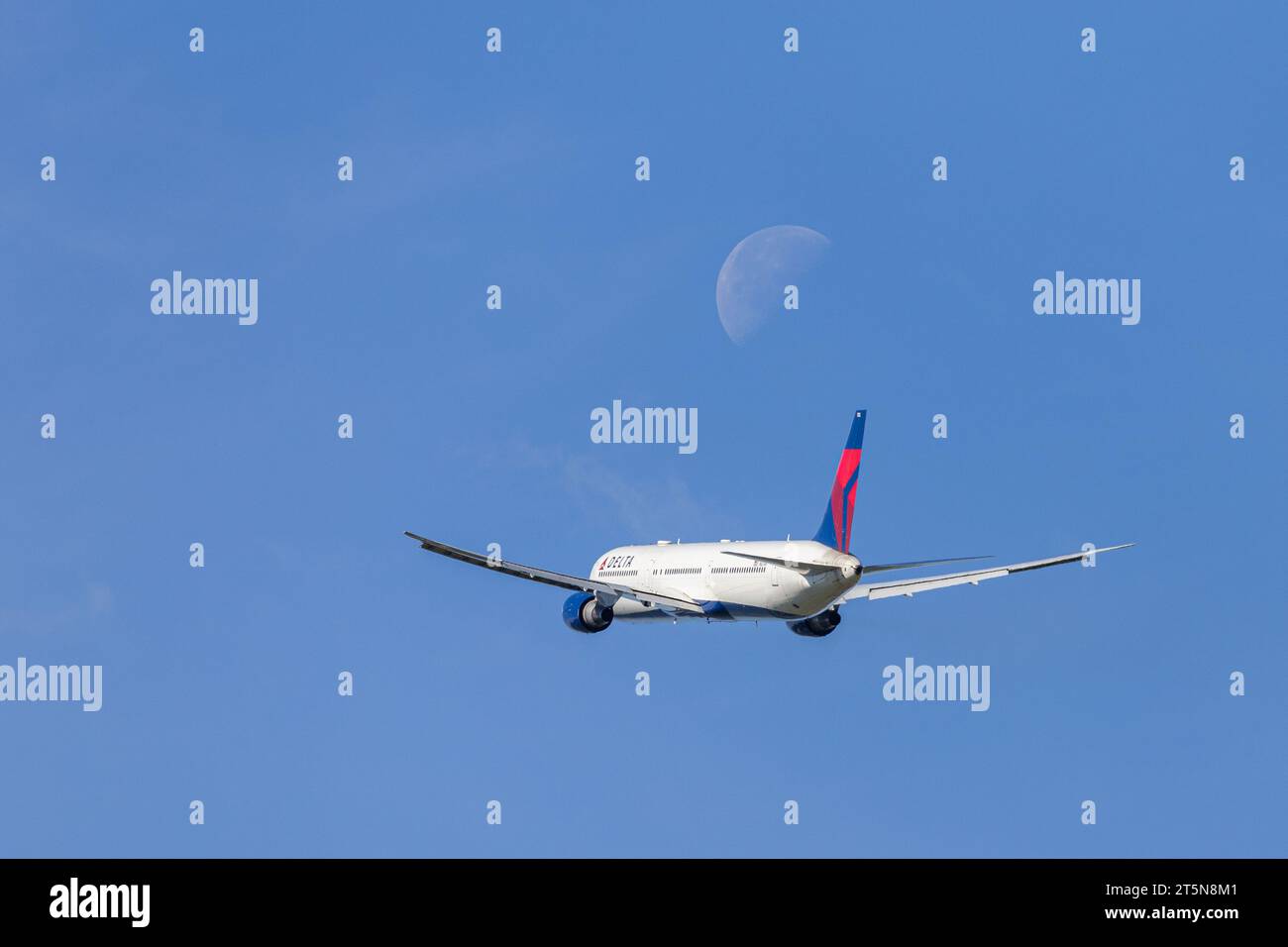 Delta Air Lines Boeing 767-432ER, registration N827MH flying out of London Heathrow LHR in perfect conditions with the moon visible in the background Stock Photo