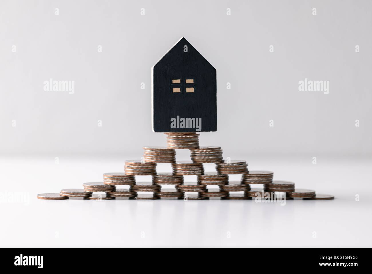 House with money. Concept of finance or refinance real estate. Symbol of house stands against background of us dollars. Property investment. Home mort Stock Photo