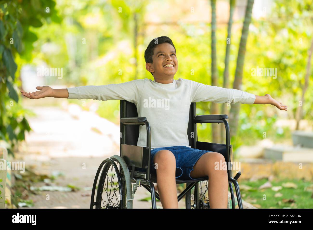 Happy indian kid with disability feeling fresh air by stretching hands