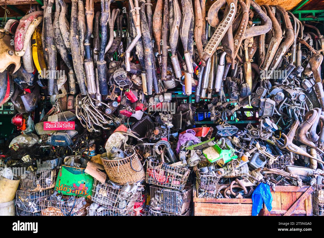 A huge collection of used mufflers and various auto parts at a mechanic