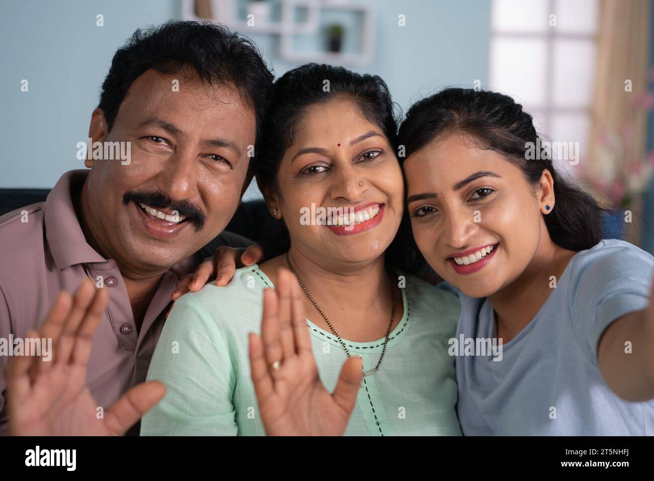 Joyful Indian family or parents with daughter talking on video call at ...