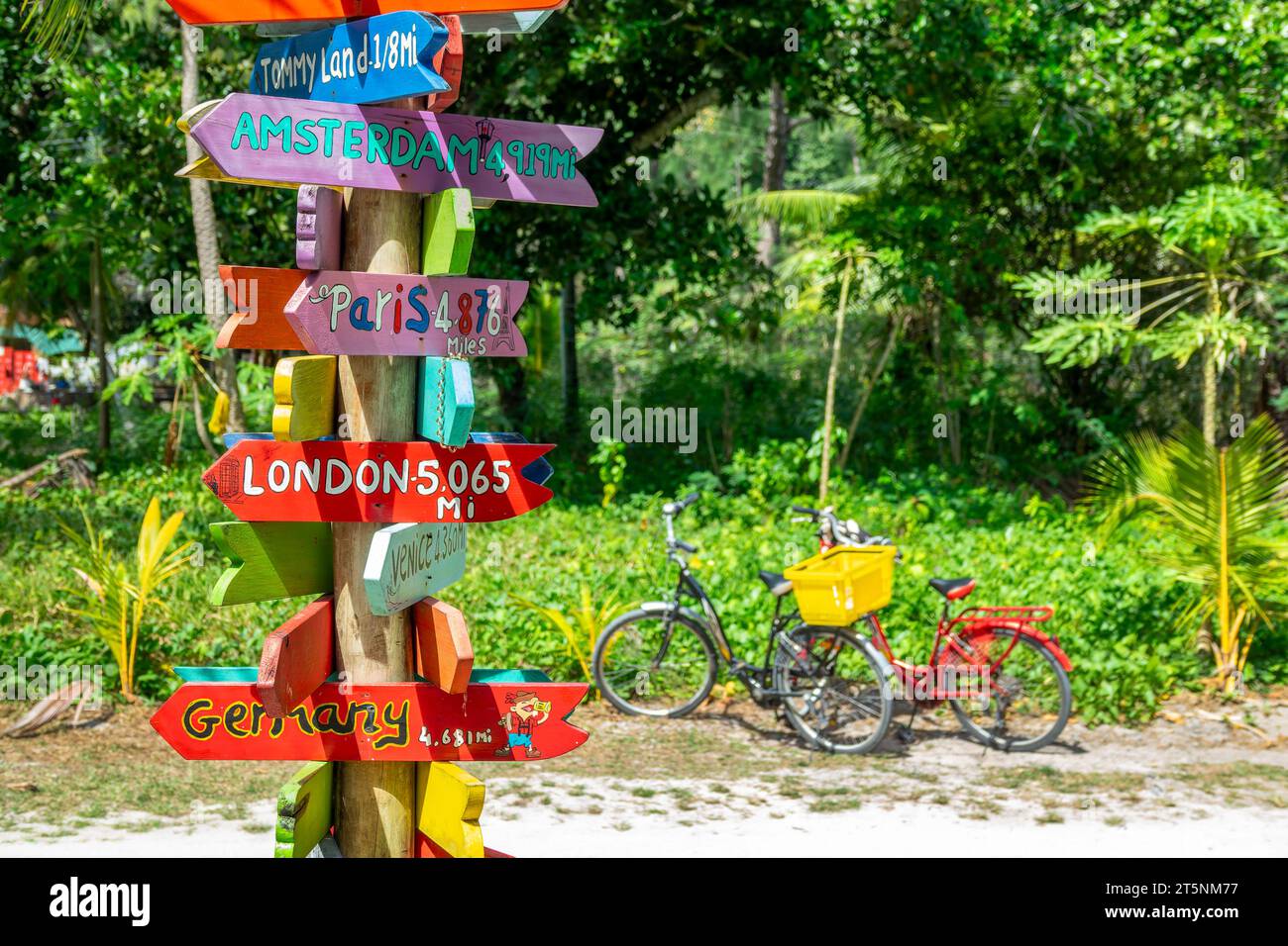 Bicycles and colorful wooden travel direction signs in La Digue island, Seychelles Stock Photo