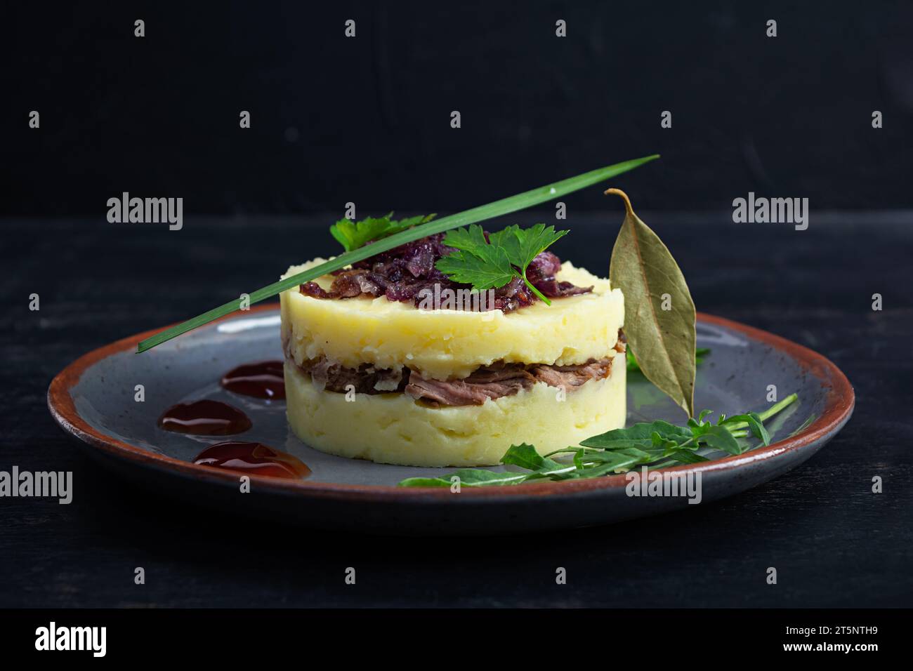 Mashed potato with beef, caramelized onion and cherry sauce Stock Photo