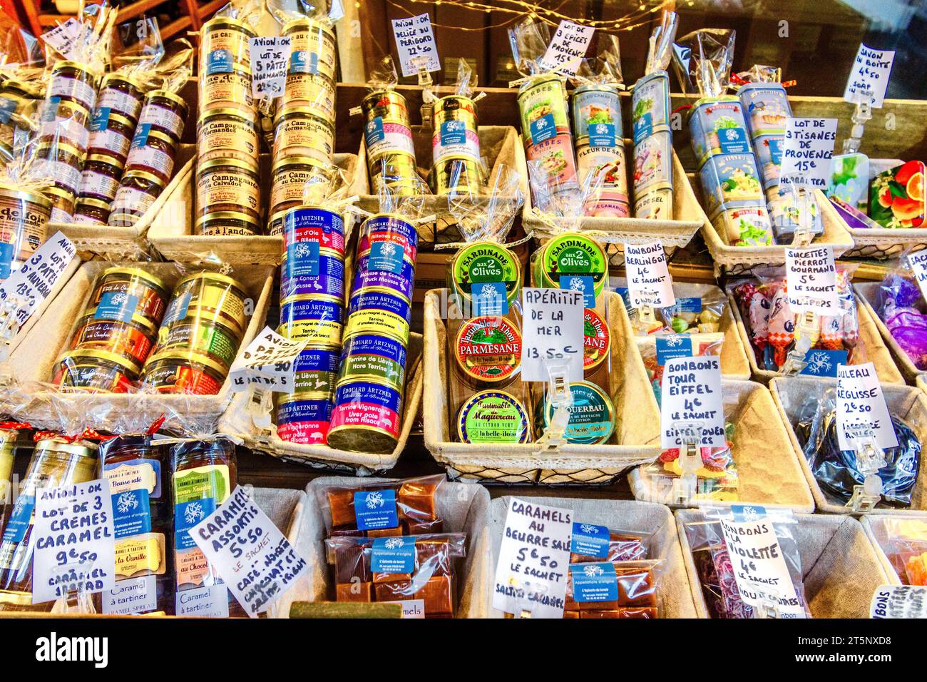 Window display of tinned sweets, olives, delicacies, herbs fish and teas marked as 'Avion OK' for safe personal export - Montmartre, Paris 18, France. Stock Photo