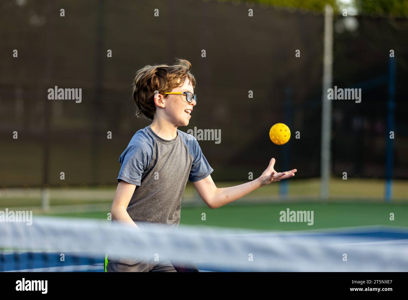Boy on court playing pickleball Stock Photo