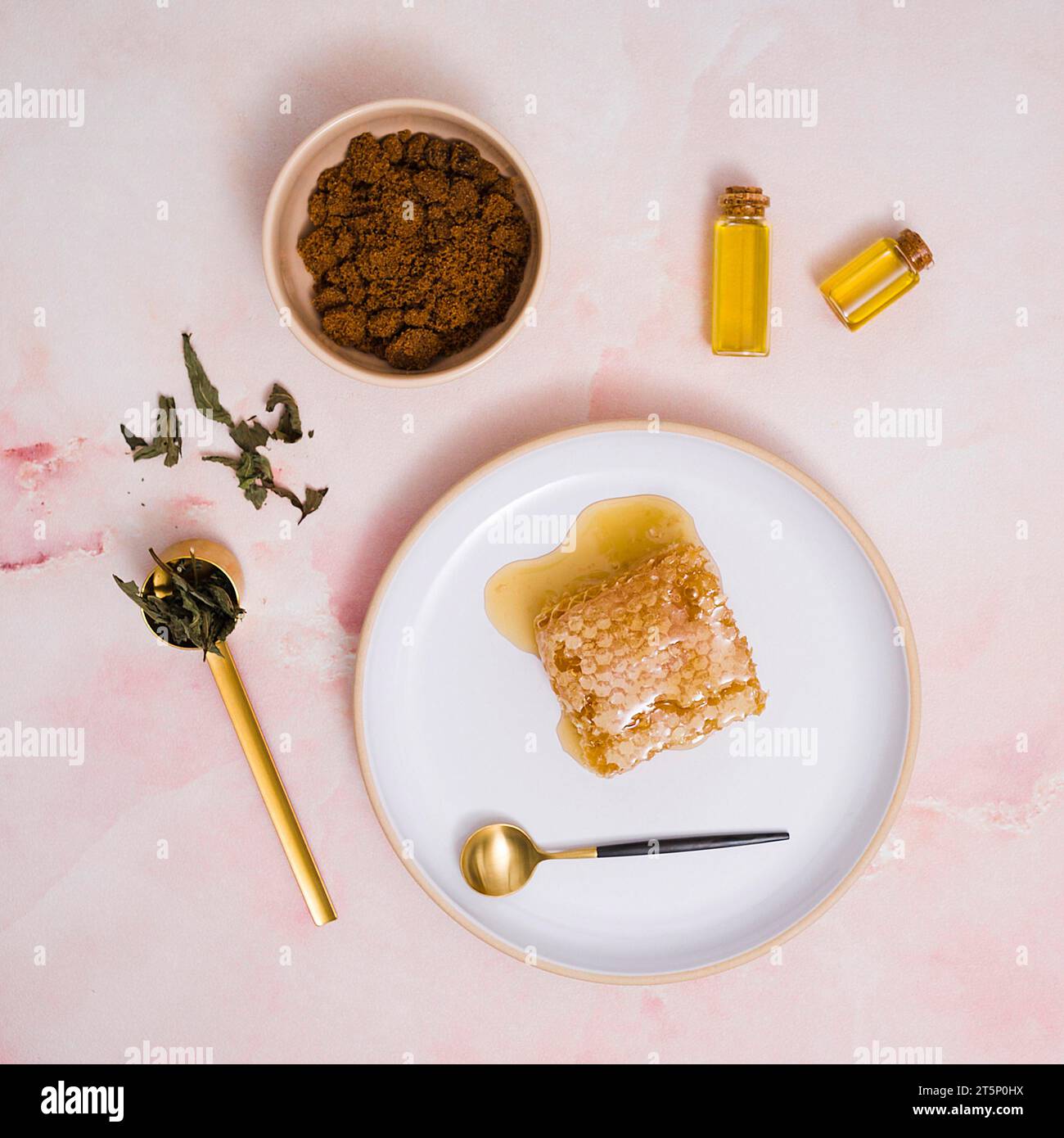 Honeycomb honey ceramic plate with cosmetics products against pink textured backdrop Stock Photo