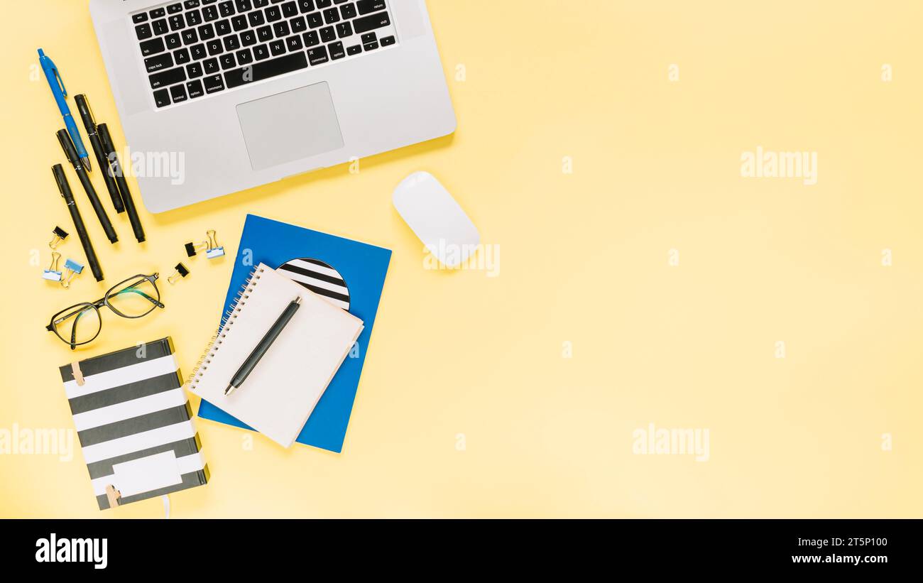 Notebooks laptop with stationeries colored backdrop Stock Photo - Alamy