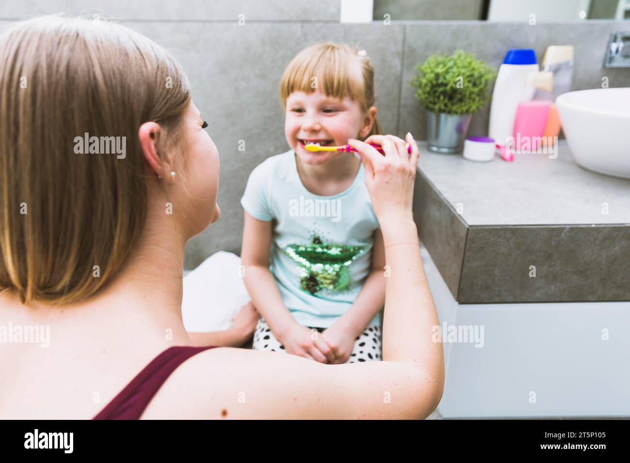 Mother brushing teeth girl Stock Photo