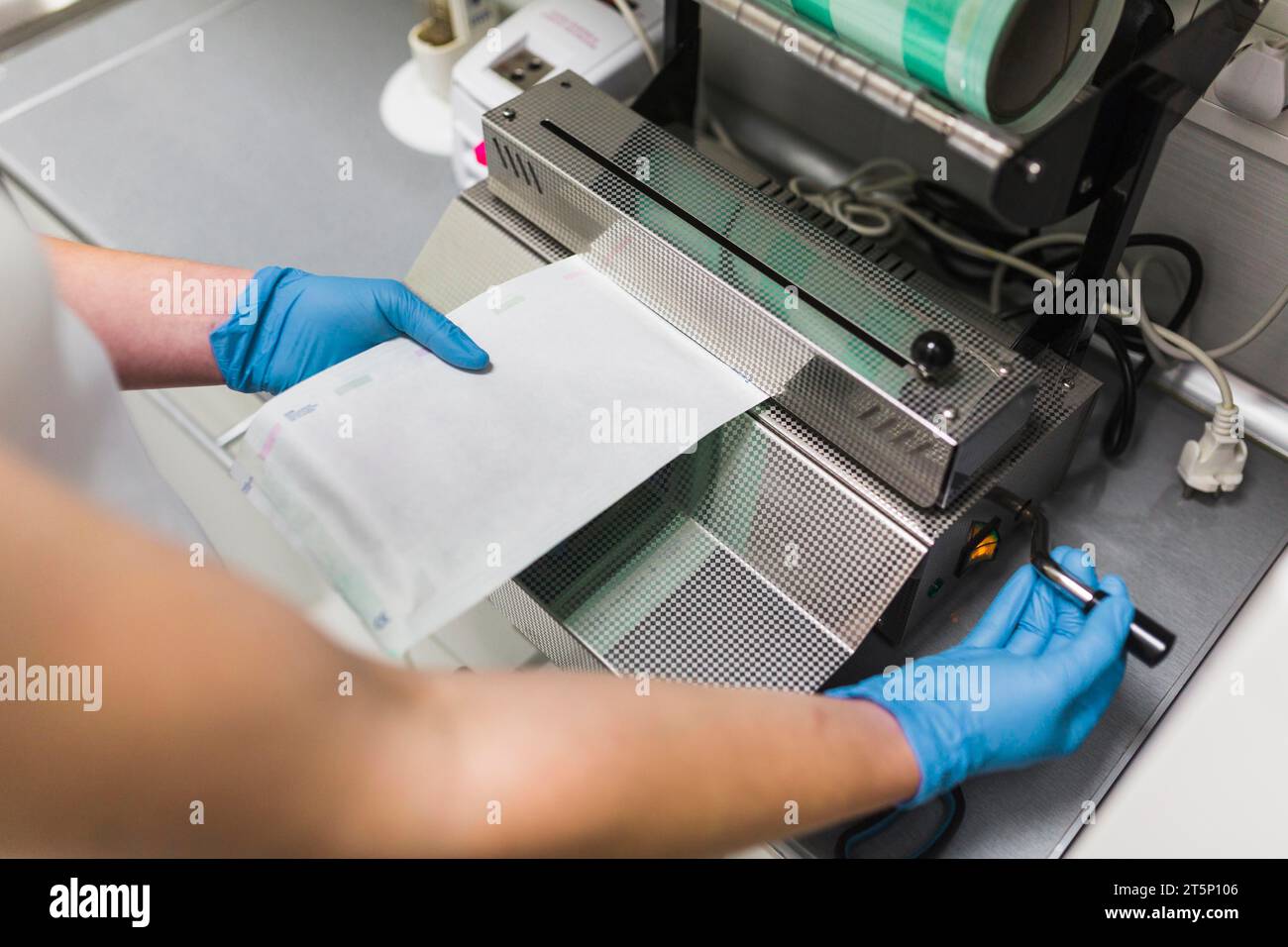 Nurse removing plastic from pouch sealer packaging machinery Stock