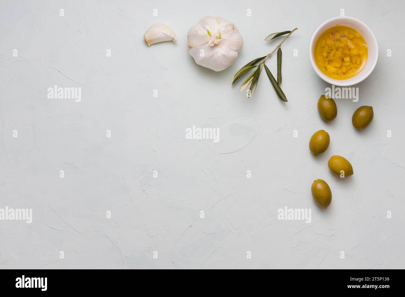 Overhead view infused olive oil garlic bowl concrete backdrop Stock Photo