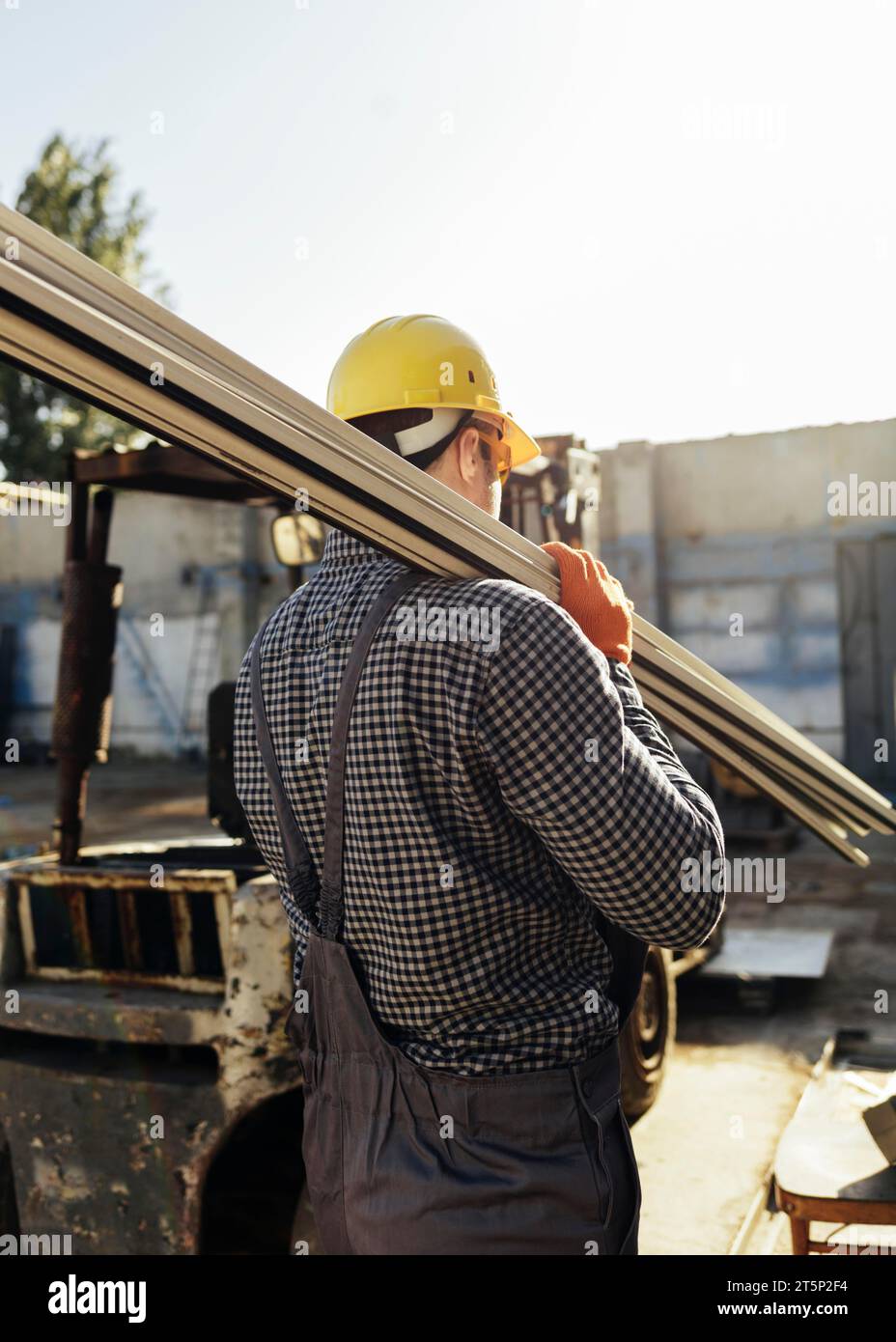 Worker with hard hat carrying wood Stock Photo