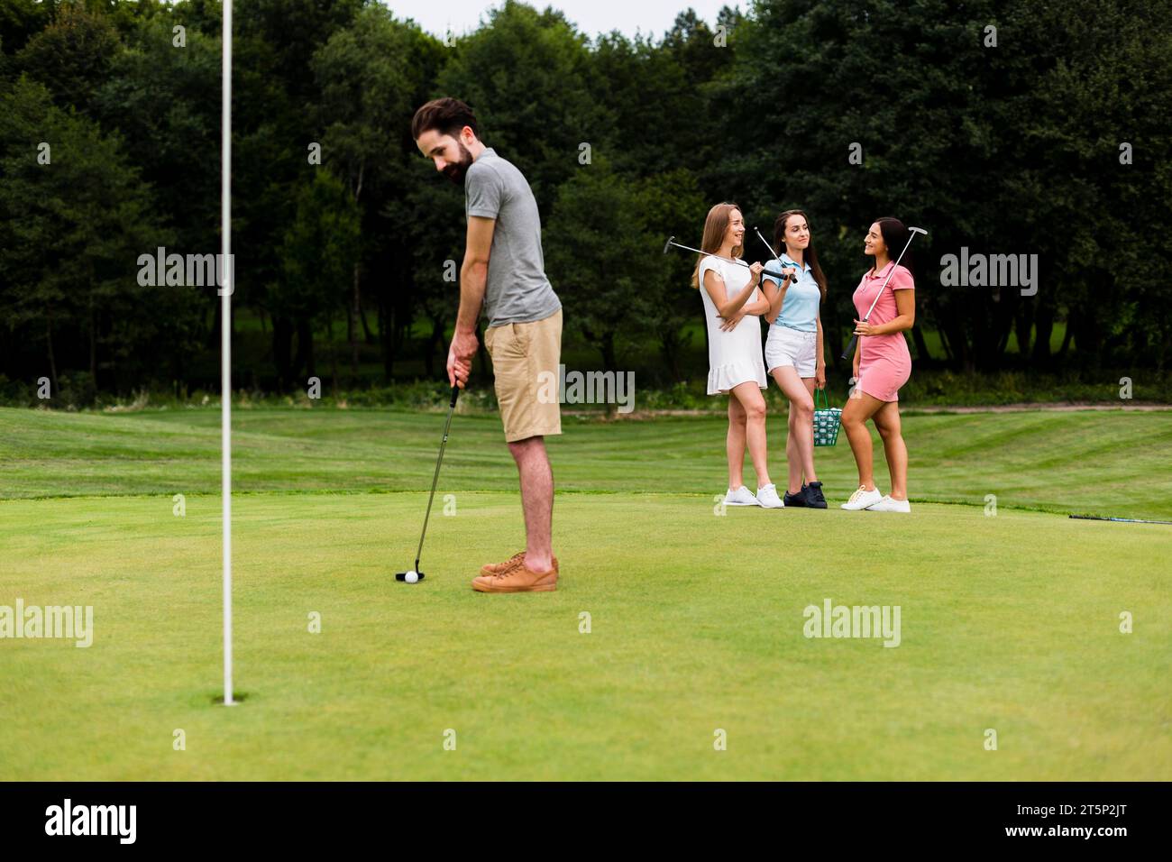 Adult fit man training golf outdoors Stock Photo