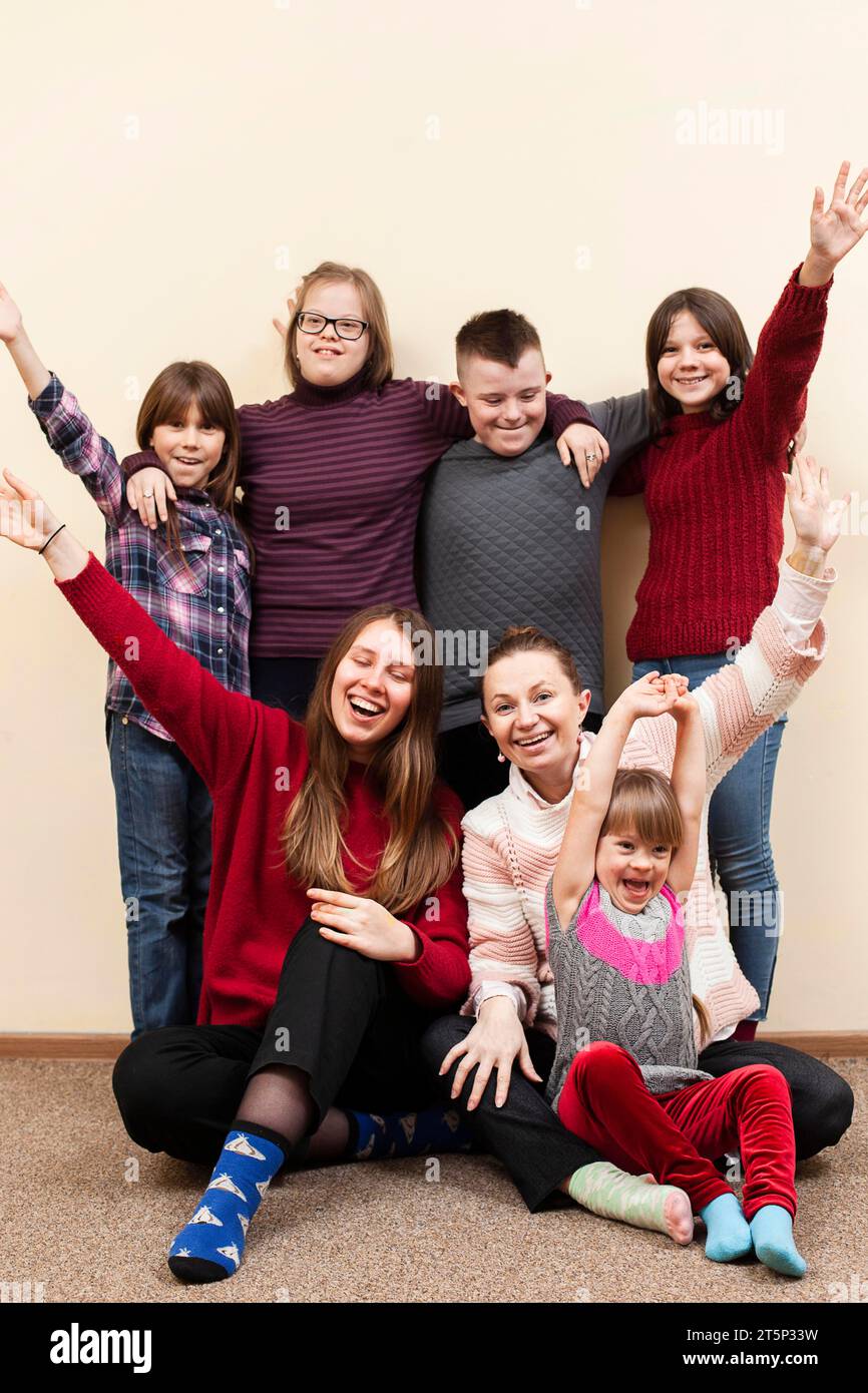 Children with down syndrome woman posing happily Stock Photo